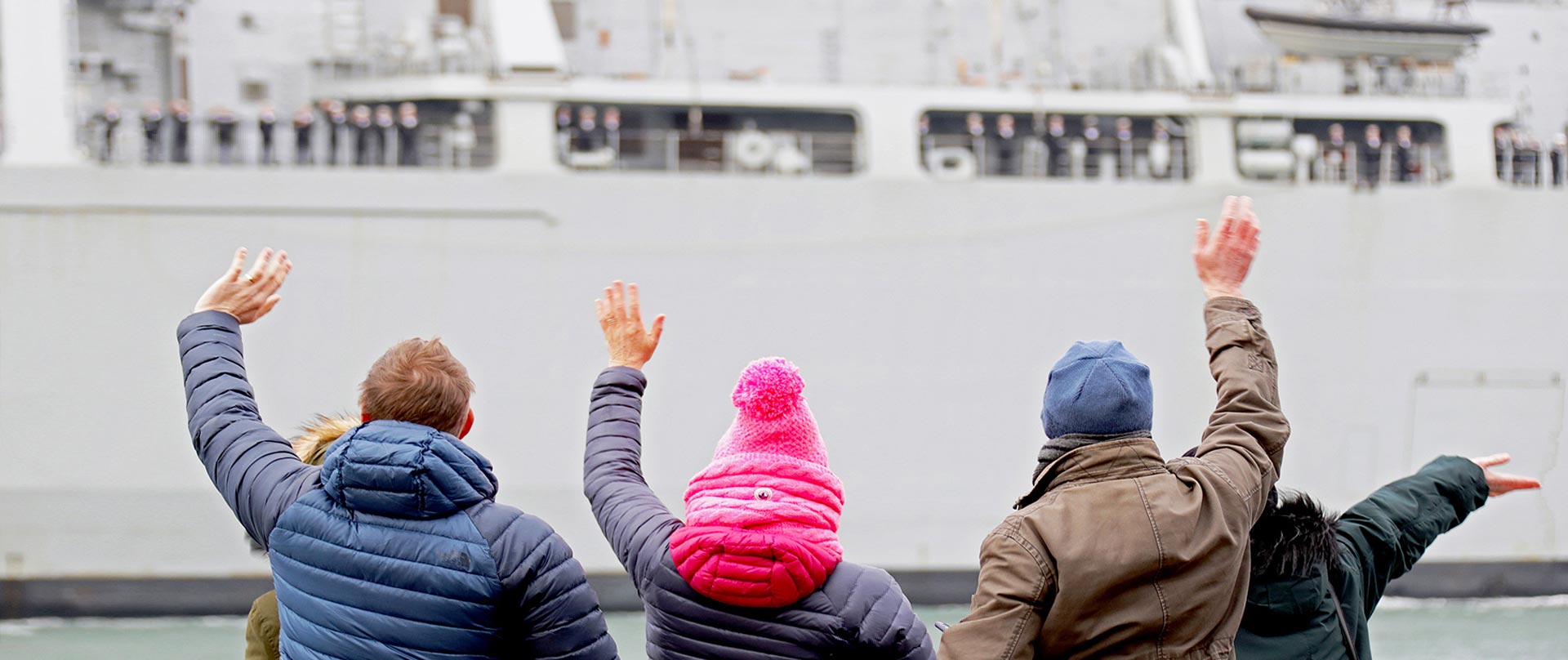 People waving at a leaving ship.